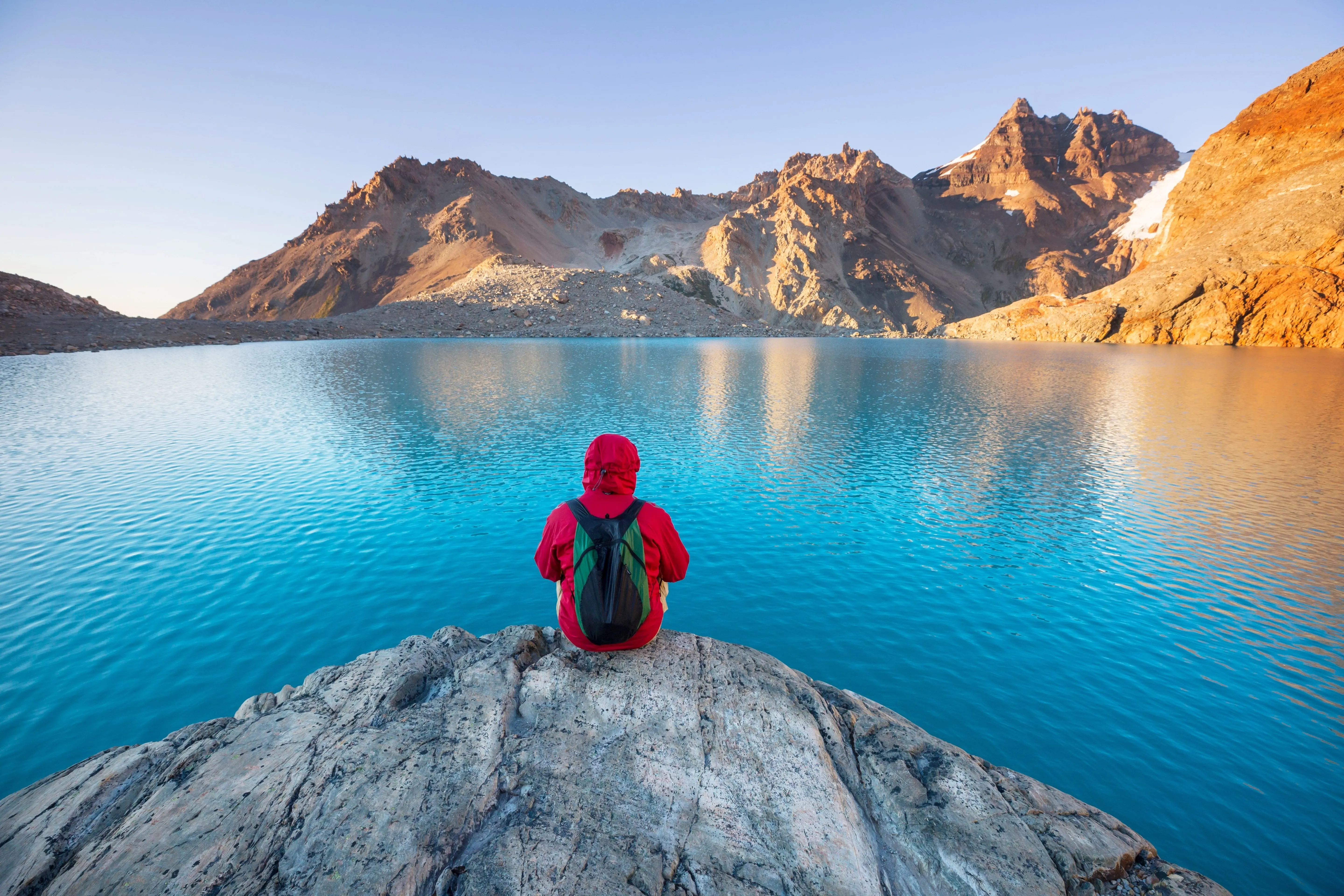 Person sitzt am Bergsee in Patagonia
