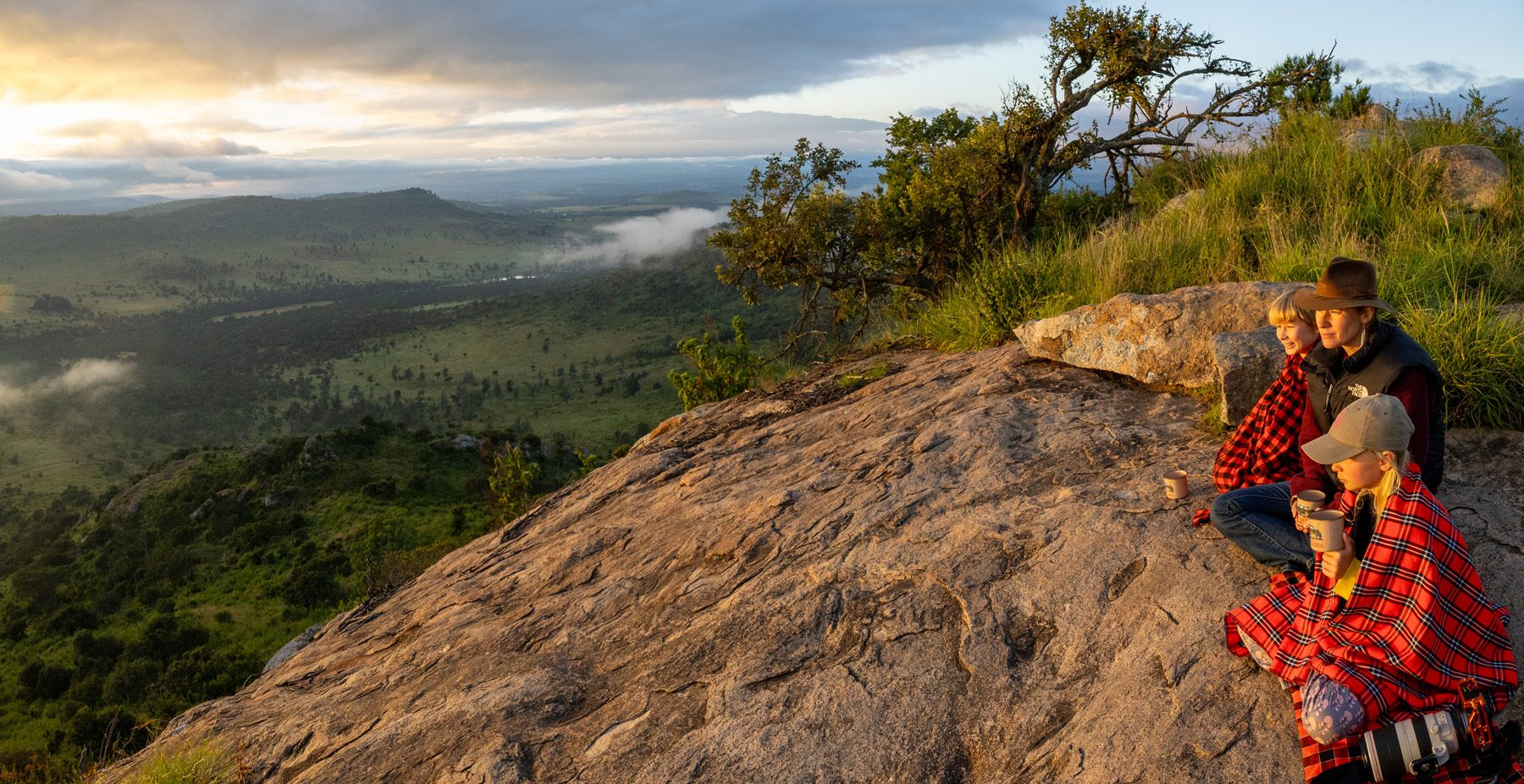 Family sitting on rock viewpoint in kenya
