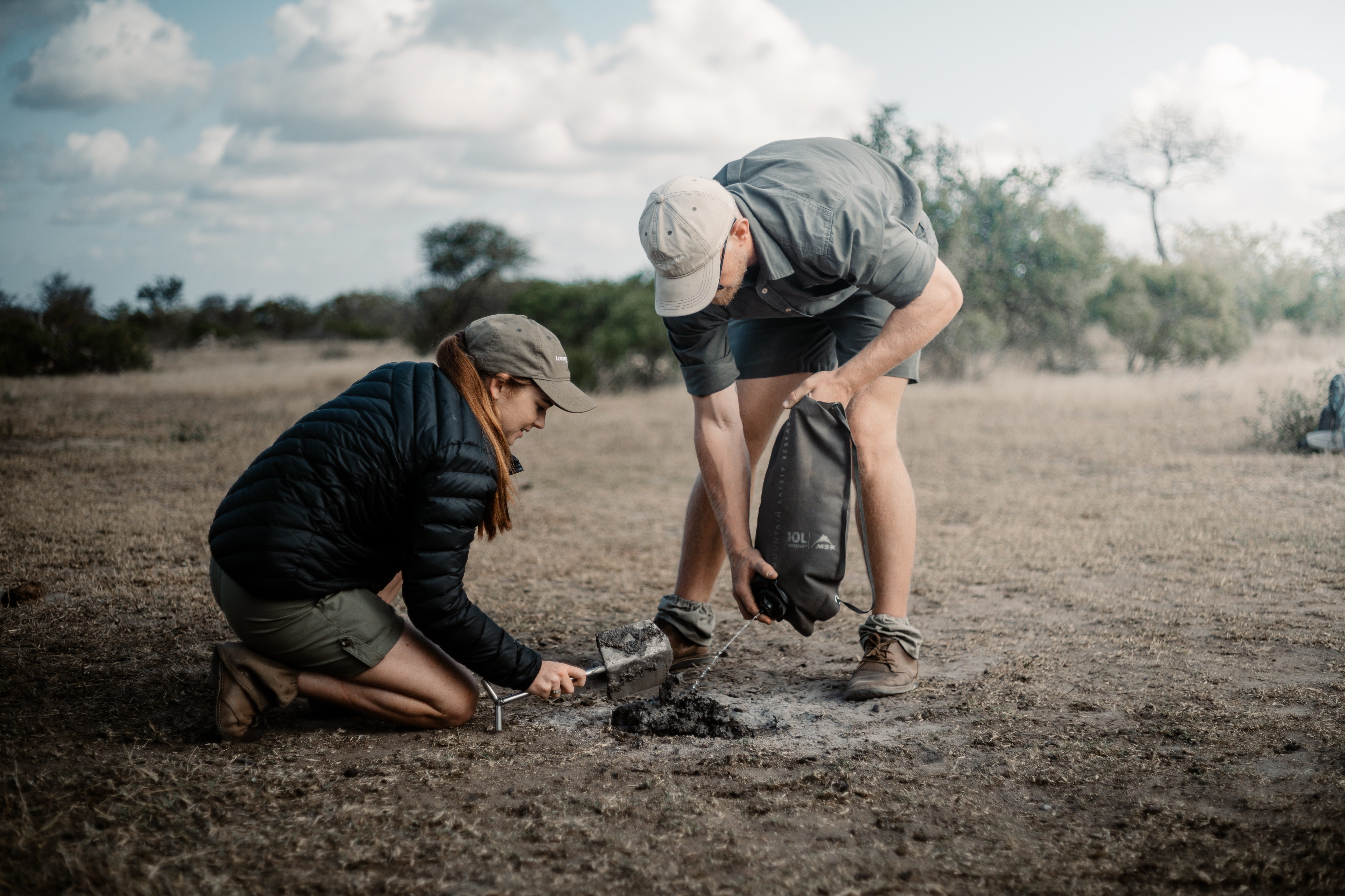 Two people analysing tracks in the African bush
