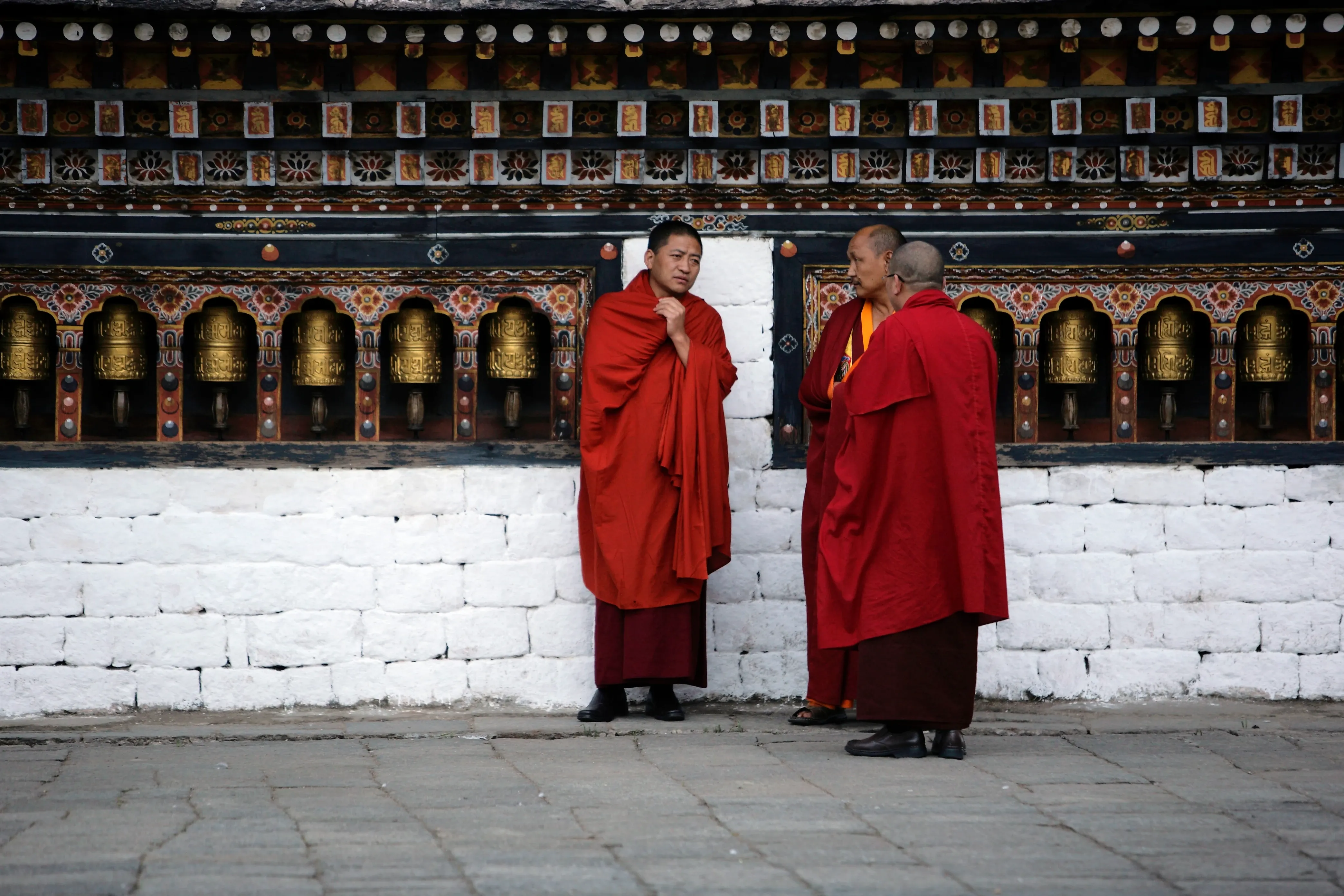 Monks by prayer wheel