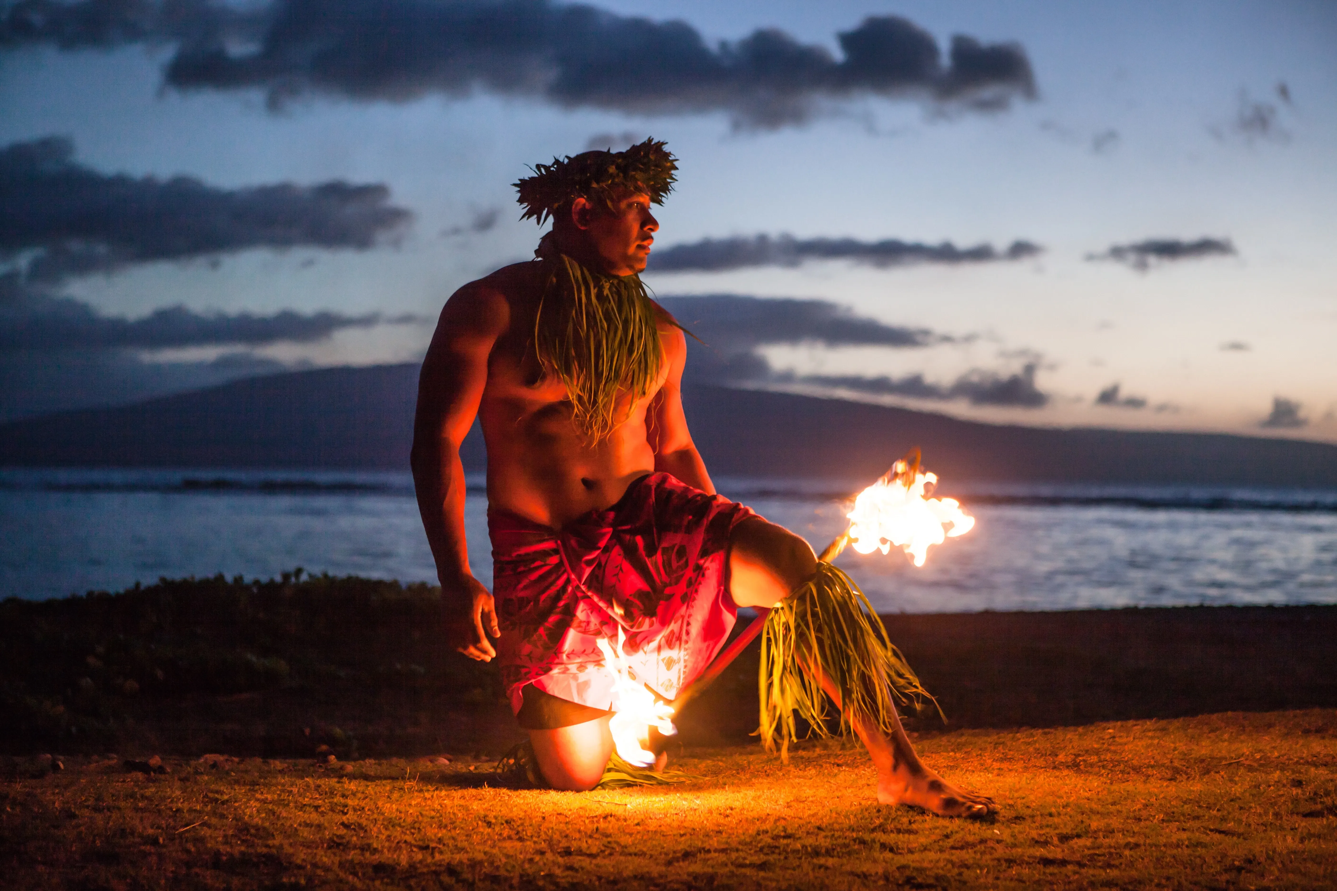 Mann mit Fakel am Strand von Hawaii