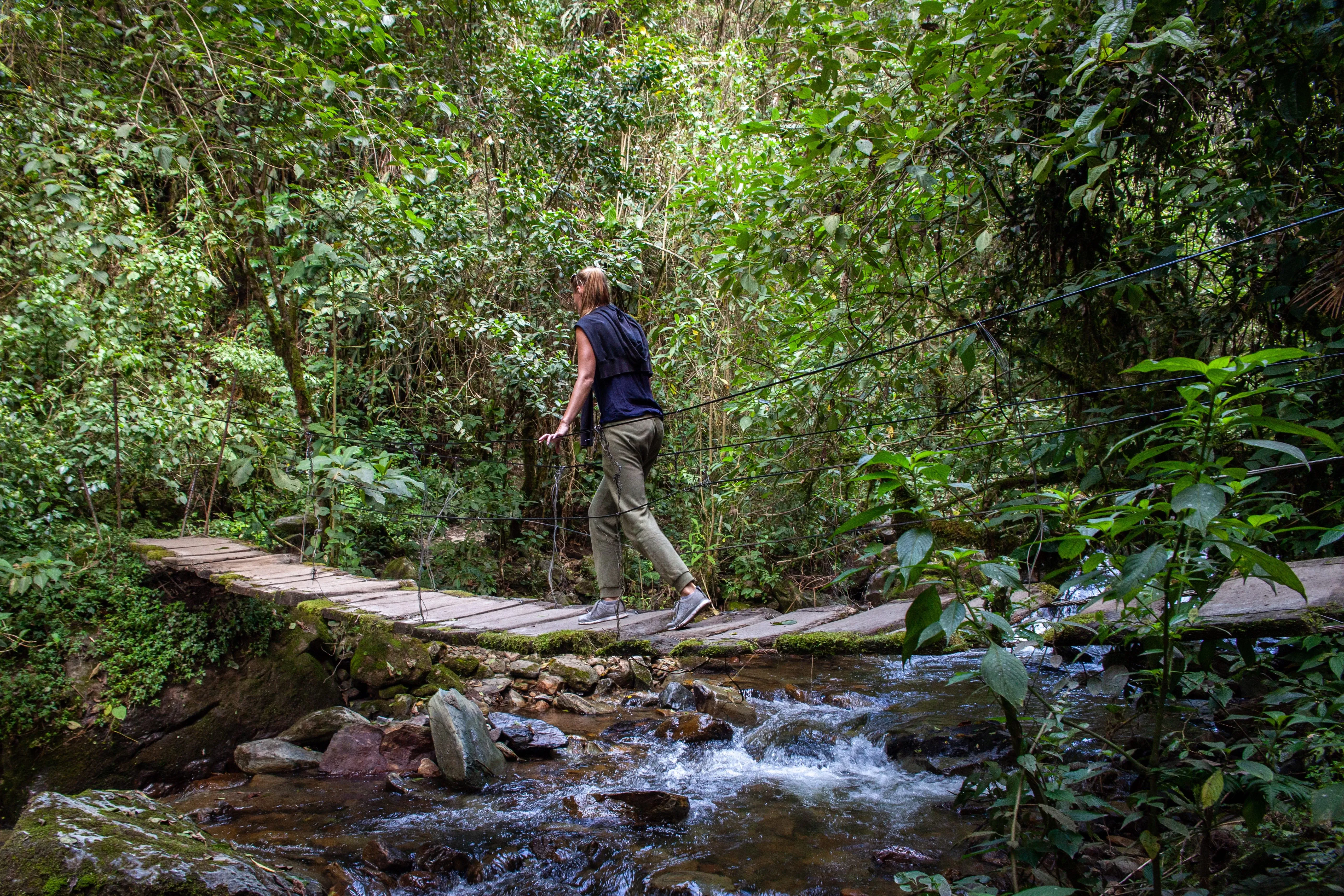 woman walking over bridge in peru