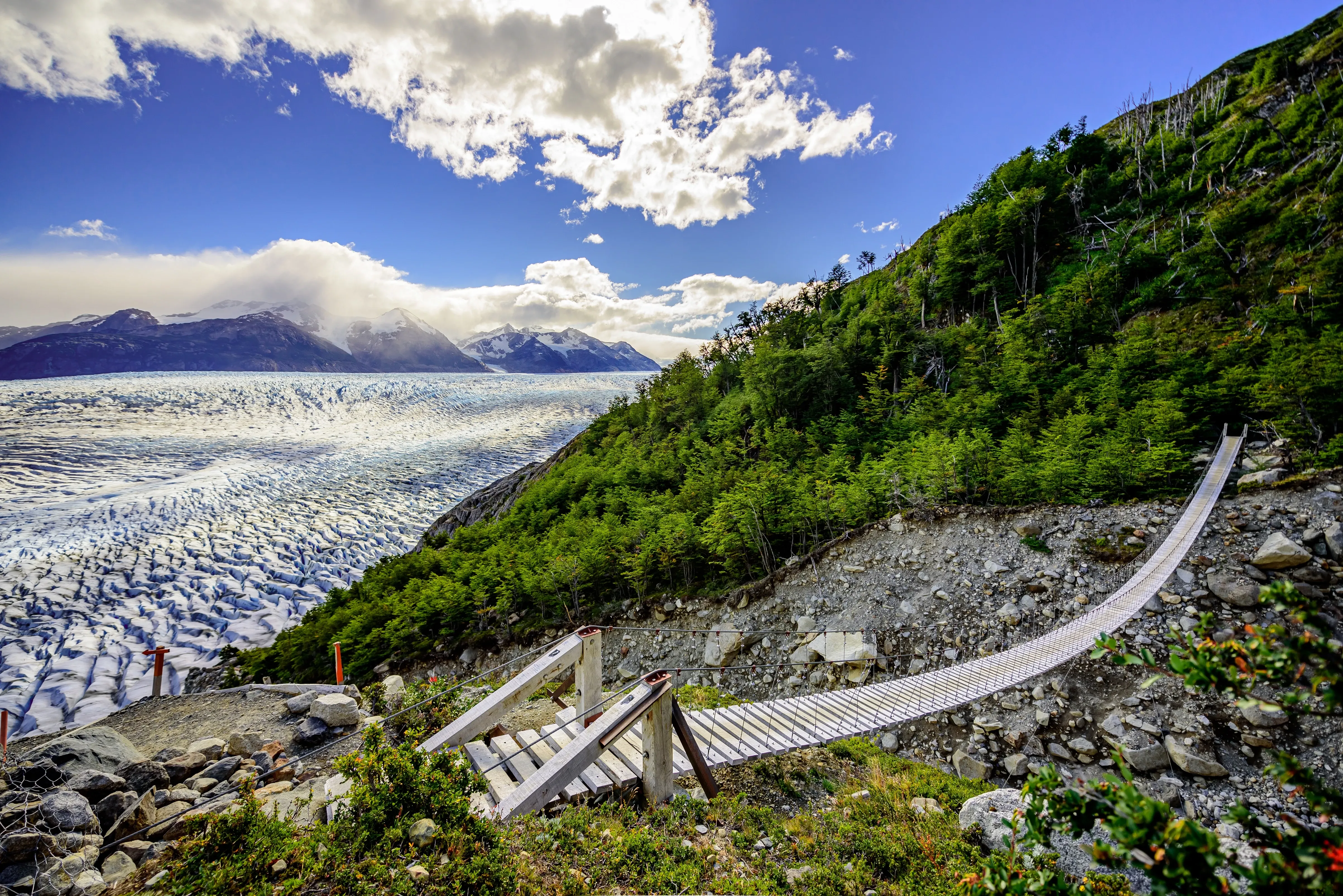 grey rope bridge by glacier