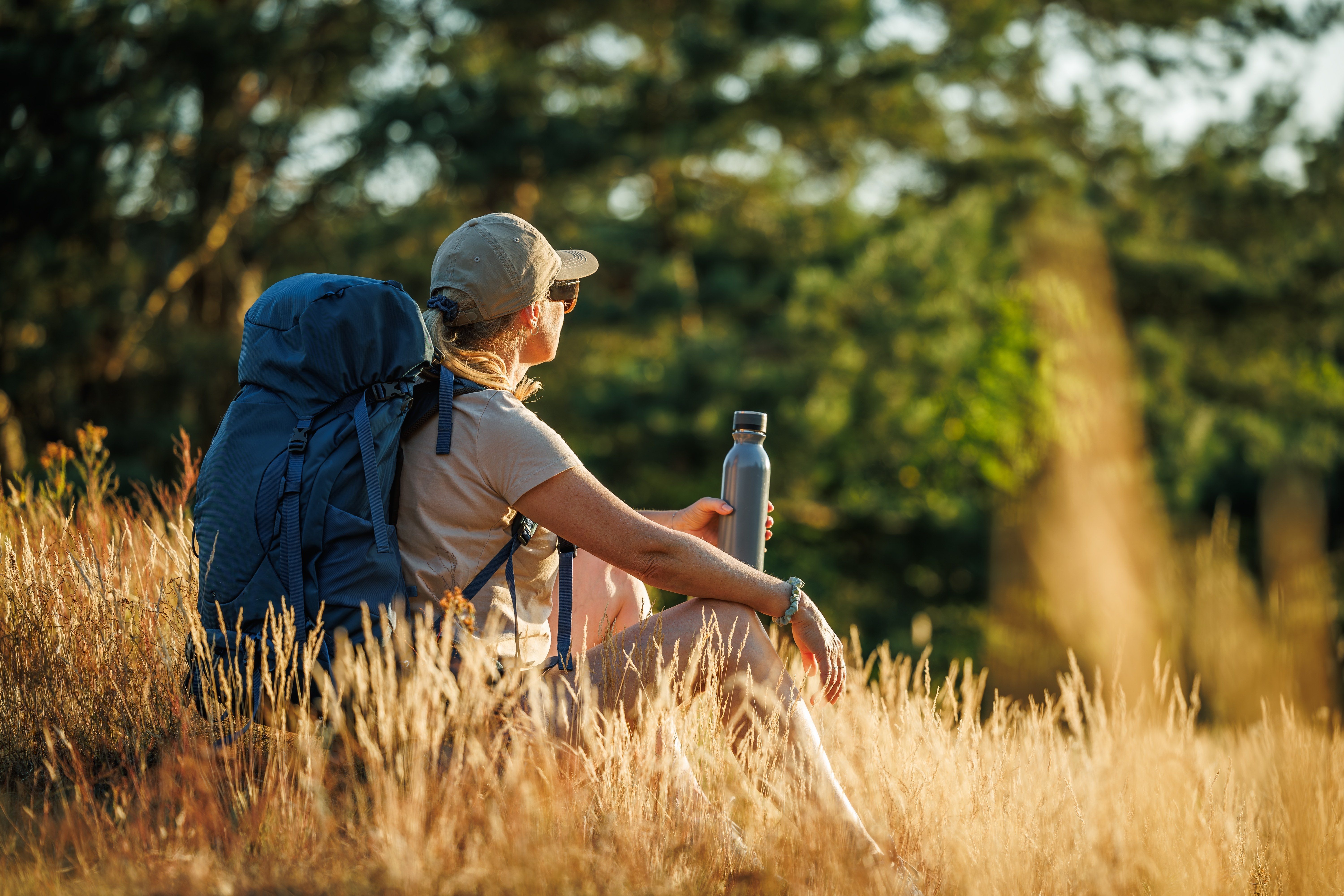 Woman sitting in the field during a hiking