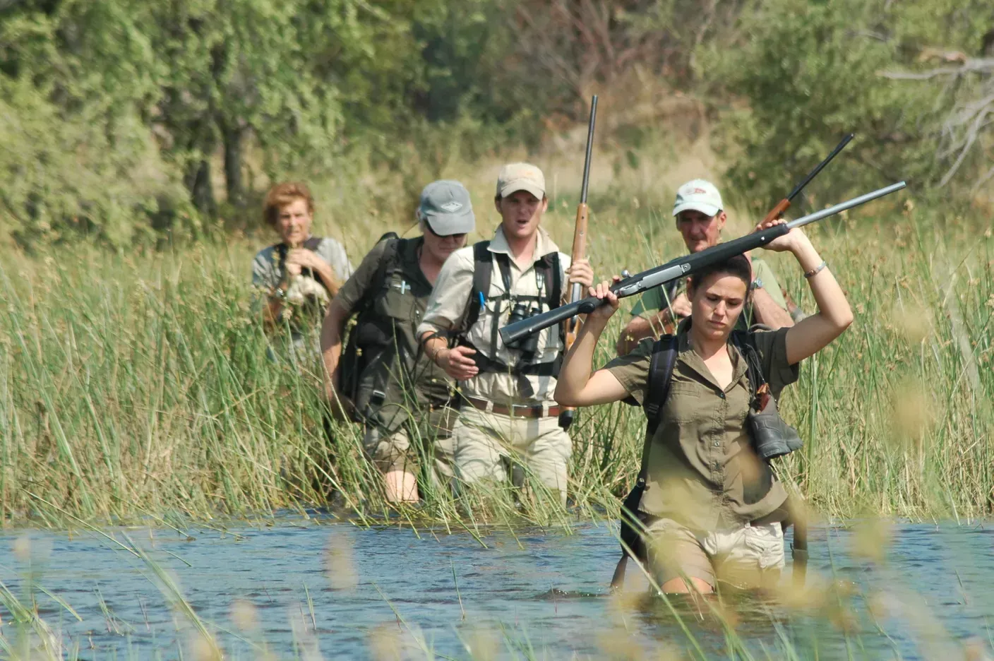 People trudge through the river in Botswana