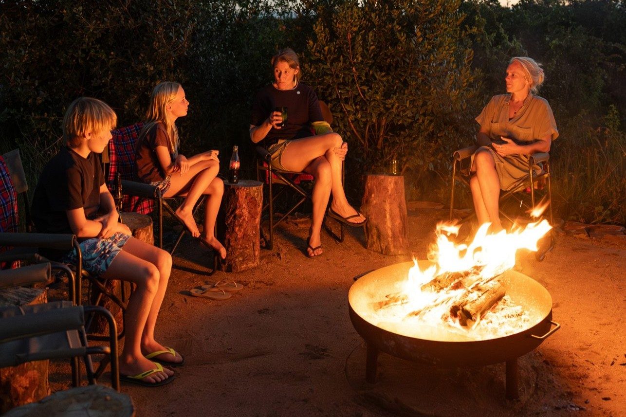 Group telling stories around campfire