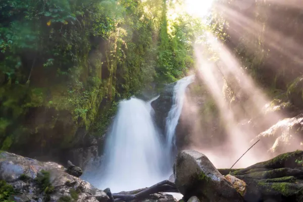 Smooth waterfall with sunrays shining through