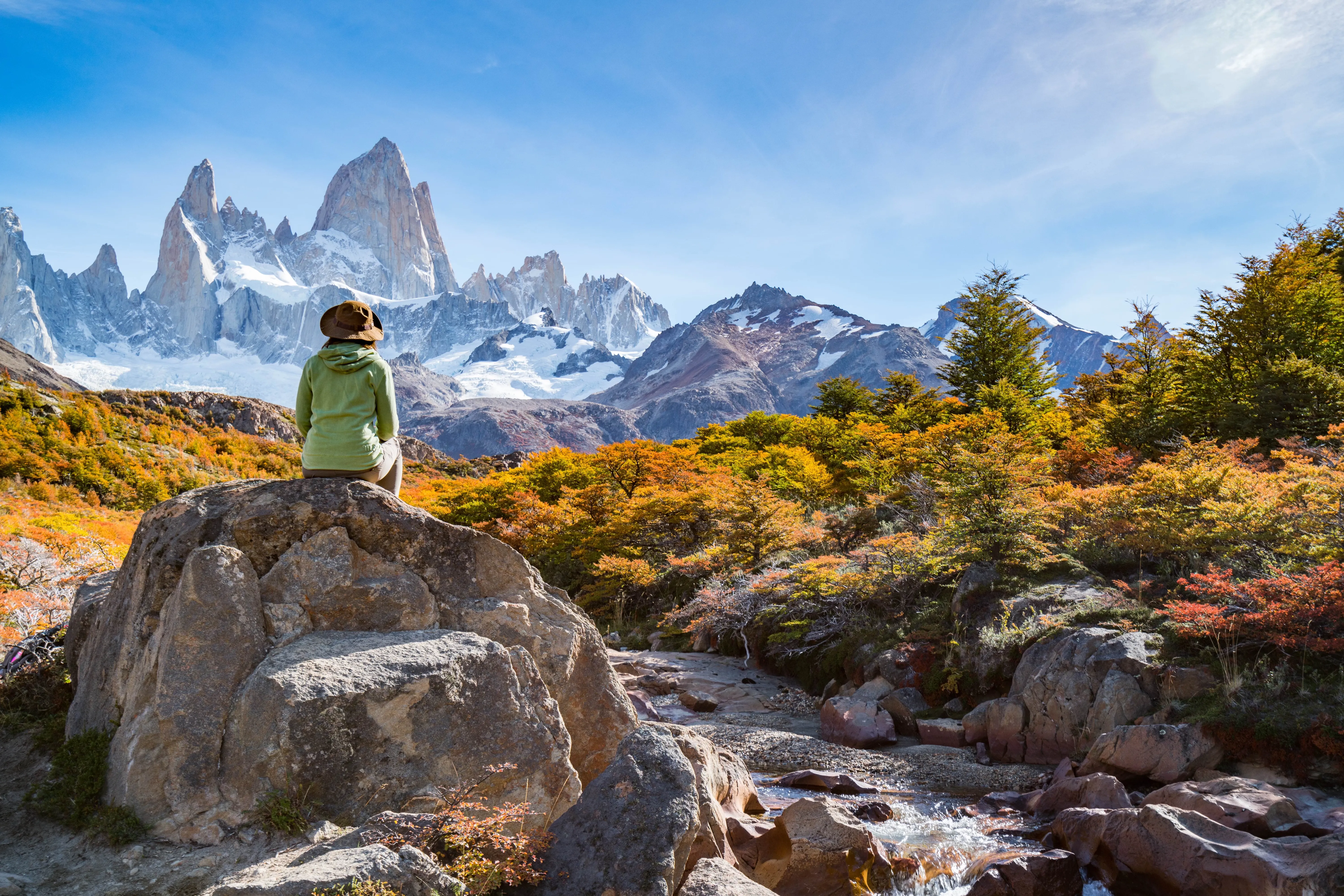 Landscape of Patagonia with a woman sitting on a rock